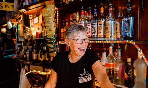 bartender smiling at customers behind bar